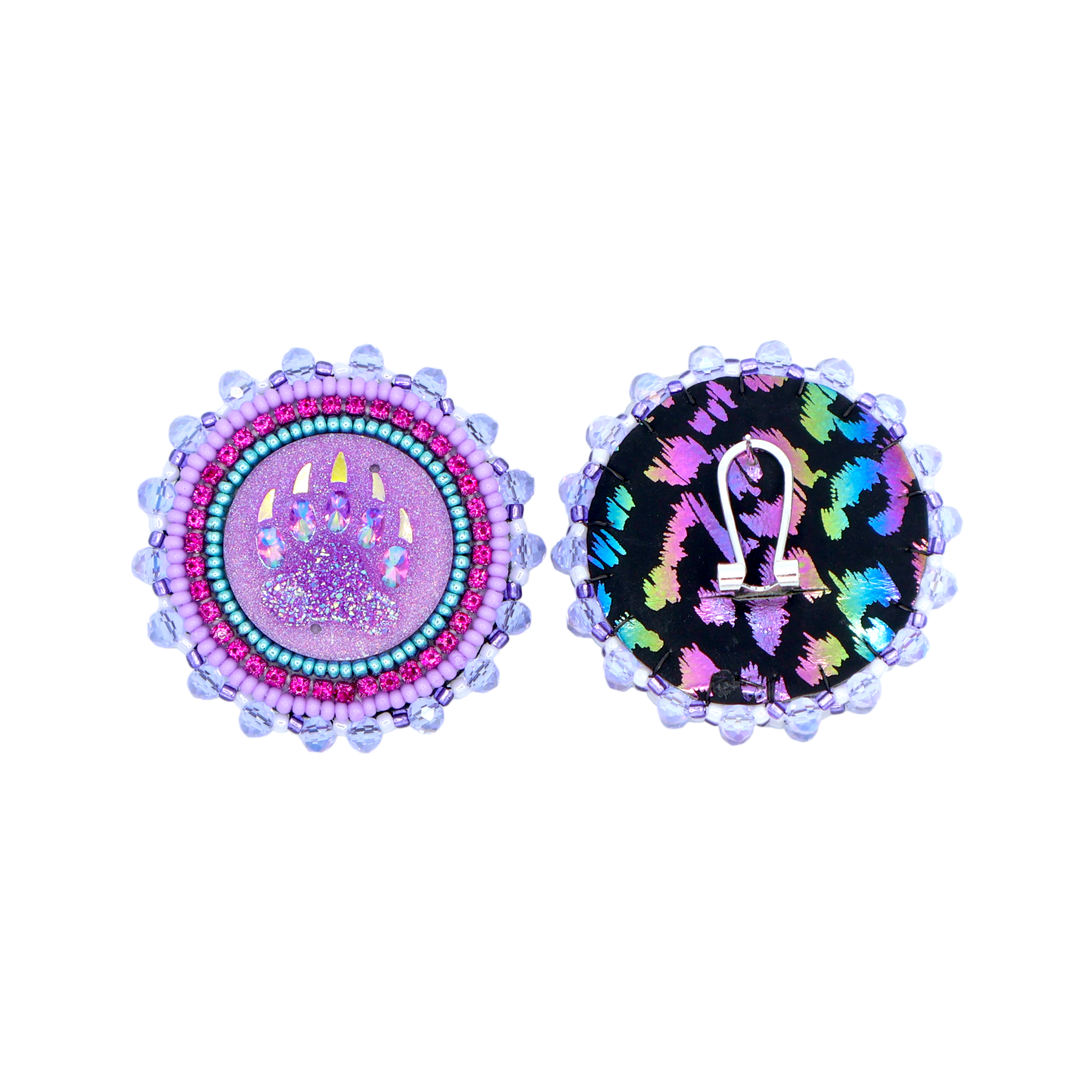Two circular stud earrings shown side by side on a plain white background. The left earring has a pink glitter center with a bear paw and turquoise and pink beaded detailing. The right erring has a colourful cheetah pattern