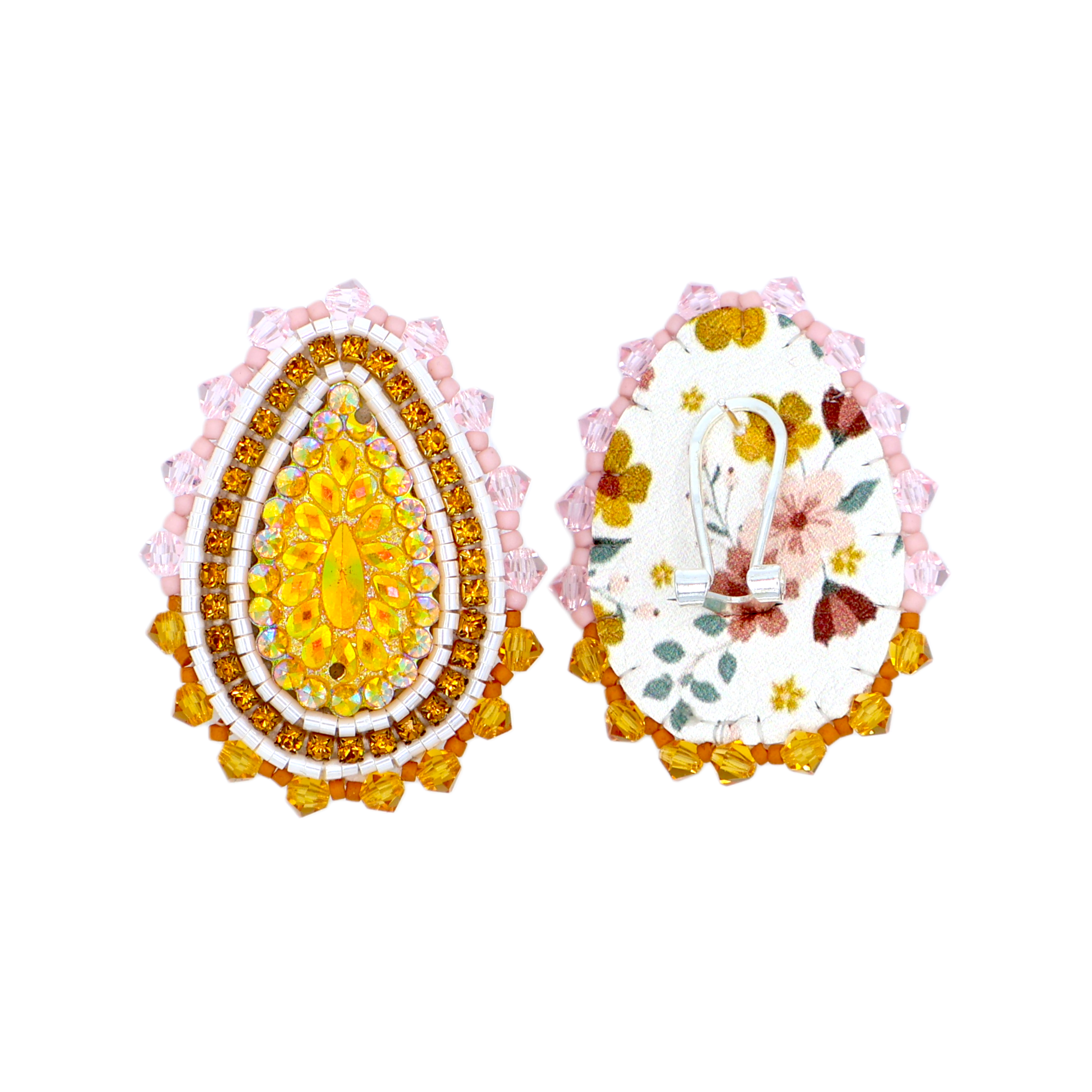 Two decorative teardrop-shaped egg-shaped accessories shown side by side on a plain white background. The left piece is embellished with rows of yellow, orange, and white rhinestones and a pink scalloped border.