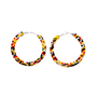 A pair of large hoop earrings made from small beads in black, yellow, orange, and white, arranged in horizontal stripes, shown on a plain white background.